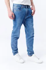 Pantalón jean de corte slim color azul medio, con bolsillos delanteros y traseros.
