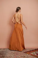 Vestido largo color ocre con escote en V, breteles finos y abertura en la cintura con detalle de aro metálico.