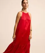 Vestido midi satinado color rojo, sin mangas, con cuello fruncido y cierre por lazo trasero.