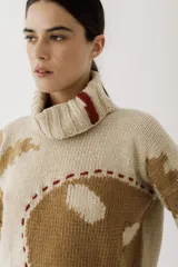 Sweater de punto color verde militar con cuello alto y bordados de hilo color mostaza.