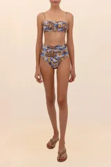 Top de bikini estilo bandeau con estampado abstracto en tonos azul, marrón y amarillo. Presenta breteles delgados, varilla interior y escote con frunces.