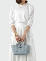 Bolso Longchamp modelo Le Roseau, color celeste, con doble asa corta, cierre con broche metálico y detalles de cuero.