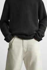 Sweater azul de punto con textura, corte holgado, cuello redondo y mangas largas con puños acanalados.