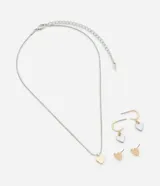 Conjunto de bisutería plateada y dorada con colgantes y aros con forma de corazón. Incluye un collar con dije de corazón dorado, un par de aros tipo argolla con dije de corazón plateado y un par de aros tipo botón con forma de corazón dorado.