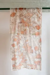 Pañuelo rectangular de seda color crema con estampado botánico en tonos naranja y marrón, realizado con hojas de eucalipto y casuarina.