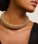 Maxi collar dorado con múltiples esferas de plástico metalizado.