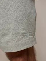 Short de baño verde agua texturizado con cintura elástica y cordón ajustable.