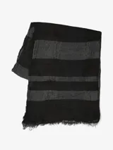 Bufanda rectangular con flecos en los extremos, con diseño a rayas horizontales en tonos negro y gris.