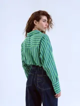 Camisa verde con rayas verticales azules, de corte cropped y manga larga.