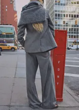 Pantalón de vestir gris de lana virgen, corte wide leg, tiro medio, con trabillas y bolsillos laterales.