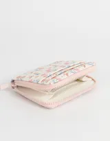 Billetera de cuerina color blanco con estampado de corazones rosas y lazos azules, cierre perimetral con cremallera y múltiples ranuras para tarjetas.