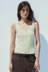 Pantalón marrón tipo barrel, de tiro medio con cintura elástica ajustable con lazada, bolsillos laterales y falsos bolsillos de vivo en la espalda.