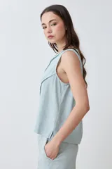 Blusa sin mangas color durazno, confeccionada en lino con efecto desflecado.