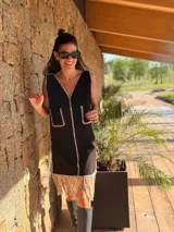 Vestido corto marrón de gamuza sintética, sin mangas, con escote en V y detalle de flecos en el ruedo. Presenta apliques bordados en el frente y laterales.