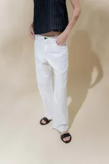 Pantalón de lino rústico color blanco, de calce recto y tiro medio. Tiene bolsillos delanteros y traseros.