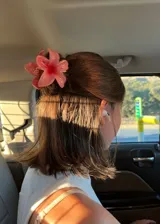 Pinza para el pelo color rosa con forma de flor.