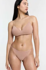 Conjunto de ropa interior color piel, compuesto por un corpiño triangular sin aro y una tanga con laterales ajustables.