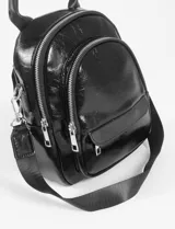 Mochila bandolera de cuero vegano color negro, con múltiples compartimentos y diseño compacto.