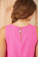Vestido corto rosa sin mangas con detalle de flor bordada en el hombro.