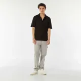 Camisa negra de manga corta con tejido de punto calado, cuello clásico y cierre frontal con botones.