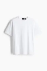Remera blanca de corte holgado con cuello redondo ribeteado y hombros caídos. Confeccionada con tejido funcional COOLMAX®, una fibra de poliéster de secado rápido que elimina la humedad y regula la temperatura corporal.