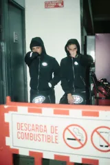 Campera negra con cierre frontal, capucha y logo estampado en el pecho.