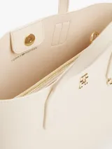 Cartera tote color crema con doble asa de mano y correa larga de tela ajustable y removible. Tiene un monedero extraíble con cierre y logo en relieve, cierre magnético y el monograma TH en la parte delantera.