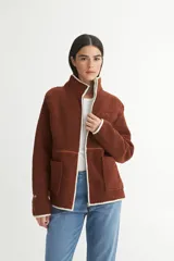 Campera marrón de sherpa doble faz combinada con nylon, cierre frontal y bolsillos cuadrados.