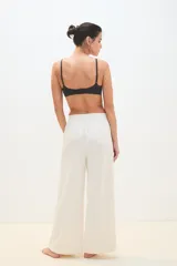 Pantalón palazzo negro con cintura elástica y una fina línea blanca vertical en los laterales.