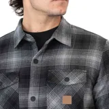 Camisa overshirt de franela a cuadros grises y negros, con forro interior de tafeta. Tiene calce regular, cierre frontal con botones metálicos, cuello camisero, dos bolsillos con tapa en el pecho y dos bolsillos laterales.