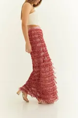 Pollera larga de fiesta color rosado con textura de flecos, calce recto y cintura alta.