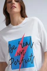 Camiseta blanca de corte holgado con estampado frontal que incluye un cuadrado azul con bordes negros y la frase "Be real Not Perfect" en letras negras con un rayo rosa que atraviesa el estampado.