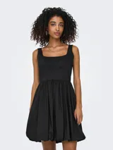 Vestido corto negro sin mangas, con tirantes finos, cintura marcada y falda con vuelo.