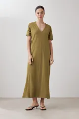 Vestido largo color verde oliva, con cuello en V, mangas cortas y costuras verticales.