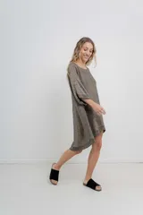 Vestido corto tejido jaspeado en tonos marrones, de silueta oversize, con escote redondo, mangas amplias tipo murciélago y terminaciones acanaladas en ruedo y puños.
