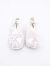 Pantuflas cerradas de tela suave color lila con estampado de corazones blancos y tirador rosa en el talón.