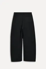 Pantalón negro de tiro bajo confeccionado en lana 100%, con bolsillos laterales ocultos y bolsillos de vivo en la espalda. Tiene pierna ancha y cierre frontal con cremallera, botón interior y ganchos metálicos.