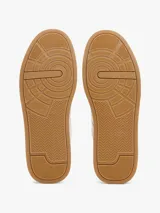 Zapatillas Tommy Hilfiger blancas de cuero, con suela marrón y detalle azul en el talón.