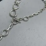 Collar plateado de alpaca con eslabones de diferentes formas y tamaños.