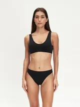 Top deportivo negro sin costuras, con breteles anchos y escote redondo.