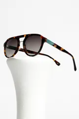 Lentes de sol Urban Haus modelo Arcadia, con montura redonda de carey y lentes degradadas.