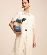 Vestido corto evasé confeccionado en laise color crudo, con cuello camisero, botones delanteros, manga corta y aberturas caladas con bordado. Incluye lazo en la cintura y bajo bordado.