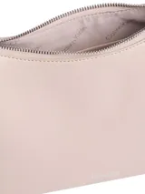 Cartera tipo hobo o baguette de piel sintética color rosa pálido, con correa de hombro ancha y ajustable. Presenta un diseño minimalista con el logo de Calvin Klein grabado sutilmente en el frente y herrajes metálicos plateados.
