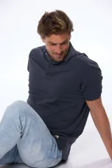 Chomba azul de piqué con cuello clásico, tapeta de dos botones y mangas cortas.