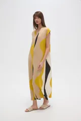 Vestido largo holgado con mangas cortas y escote en V. Presenta un estampado abstracto con formas onduladas en tonos beige, amarillo mostaza, blanco y negro.