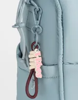 Cartera shopper negra de tela deportiva con doble asa corta estampada, correa regulable y desmontable, cierre superior con puller de goma y charm lateral.