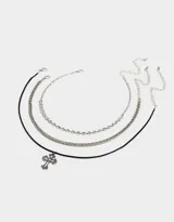 Set de tres chokers plateados y negro. Incluye un choker de cordón negro con dije de cruz plateada, un choker de cadena gruesa plateada y un choker de cadena fina plateada.