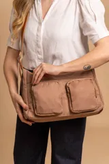 Bandolera de tafeta impermeable, liviana, con dos compartimientos principales, dos bolsillos con cierre y correa regulable con hebilla.