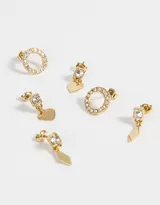 Set de tres pares de aros dorados con strass. Incluye un par de aros pasantes con forma circular, un par con dije de rombo y un par con dije de corazón.