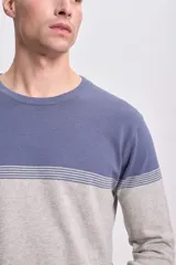 Buzo de punto gris claro con franjas horizontales en el pecho y mangas largas.
